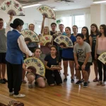 American K-Drama fans learning traditional Korean fan dance in a workshop setting